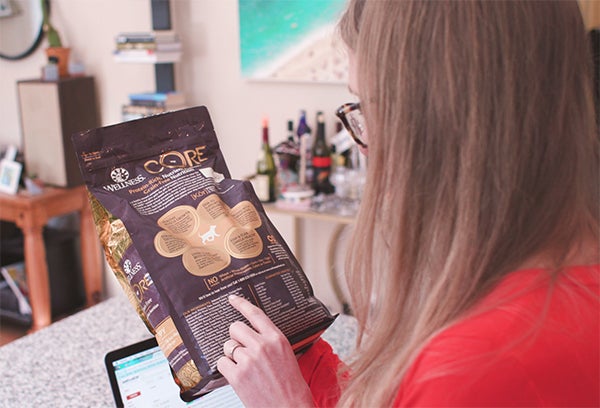 woman looking at dog food ingredients, Preparing Your Home for a New Puppy