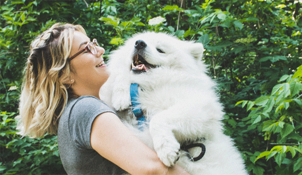 Person snuggling dog outside