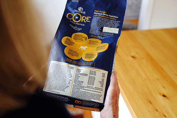 Woman holding Wellness Core Puppy dog food, is fish oil good for dogs